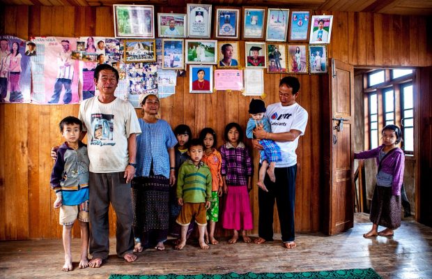 Une Famille dans l'état Kayah. Au mur, des portraits de famille et des diplômes scolaires.