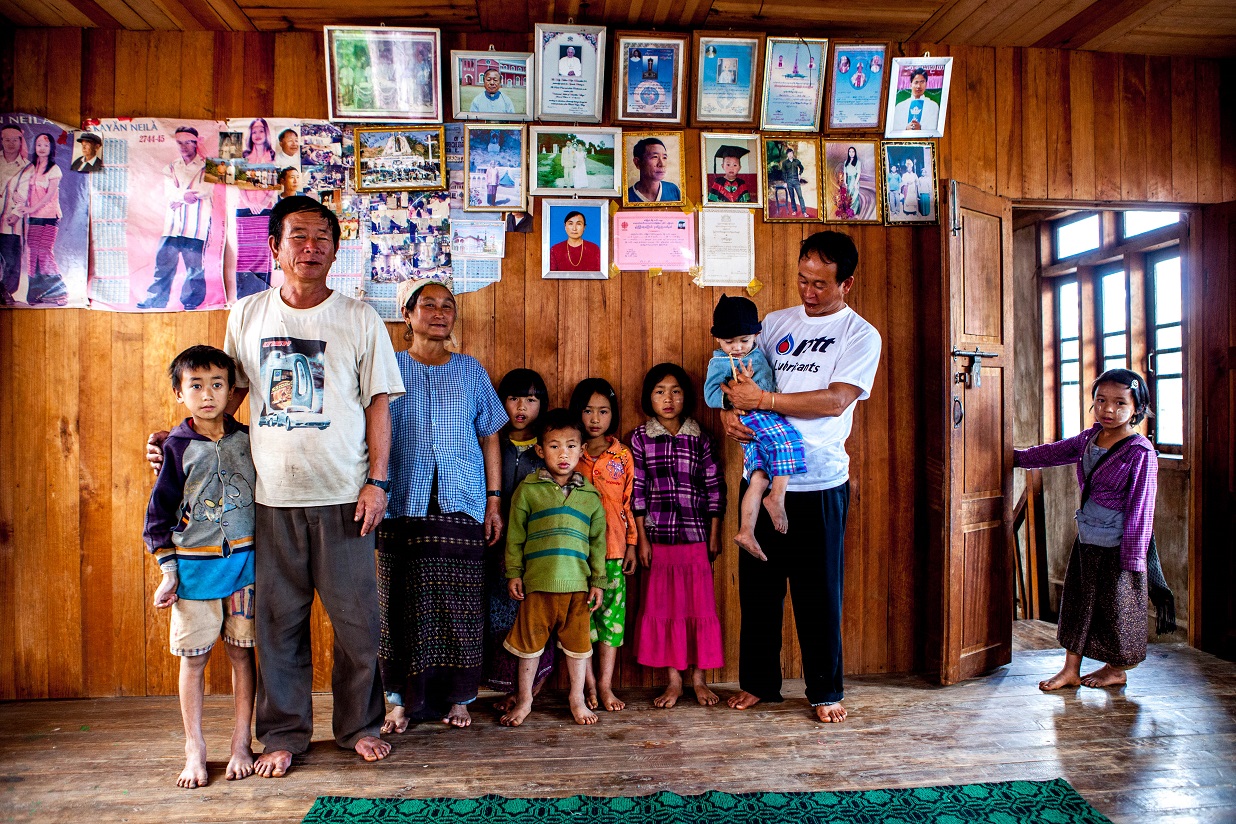 Une Famille dans l'état Kayah. Au mur, des portraits de famille et des diplômes scolaires.