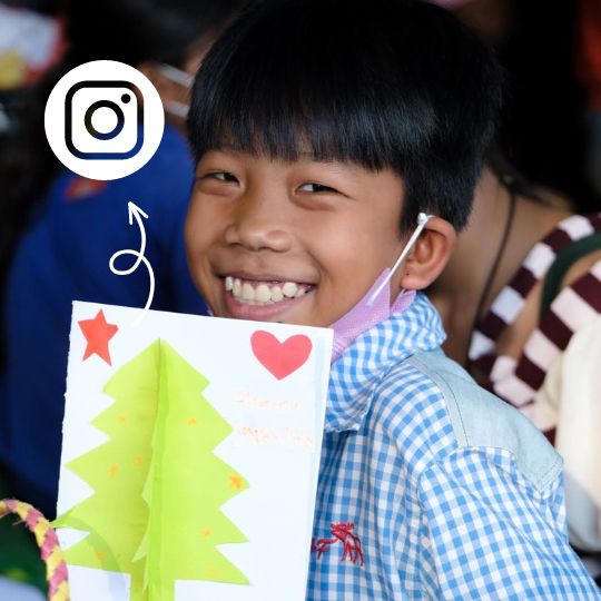 Un garçon au Cambodge avec une carte de Noël