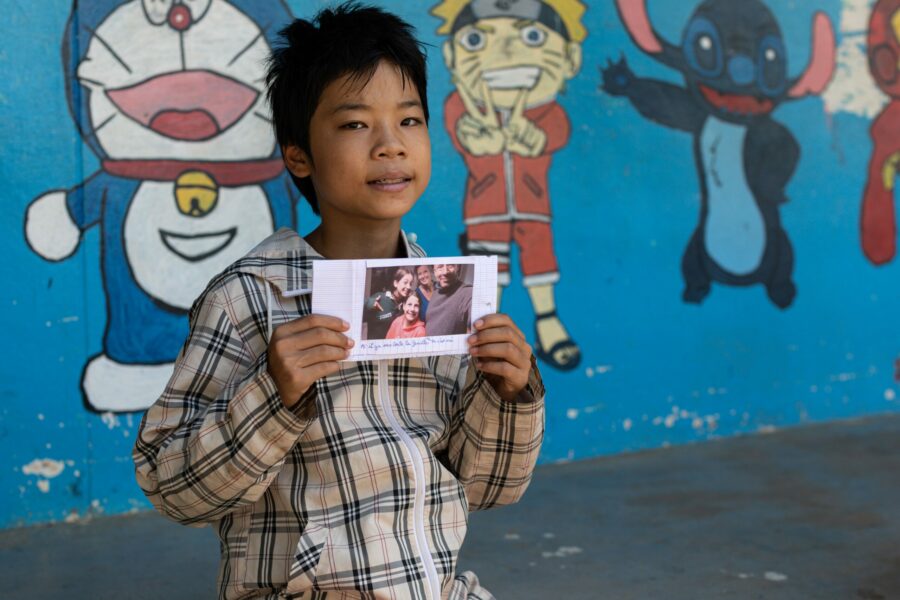 Un petit garçon vietnamien avec la lettre de la famille qui le parraine